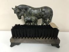 A cast iron horse door stop and brush