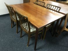 A late 20th century teak dining table and four rail back chairs