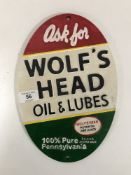 A cast iron Wolfs Head Oil plaque