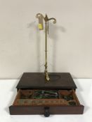 A set of portable brass pan scales with weights in a mahogany drawer