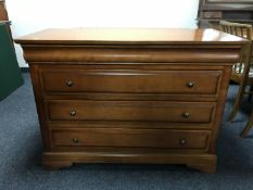 A contemporary four drawer chest in a walnut finish