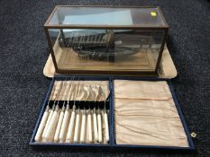 A tray of boxed table cutlery and a plated Viking long ship in case