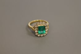 An 18ct gold emerald and diamond cluster ring,