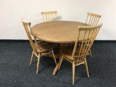 A circular teak extending table and two chairs plus four Ercol high back chairs