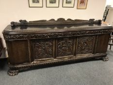 An impressive continental carved mahogany sideboard on oversized paw feet