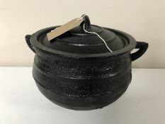 A cast iron three leg pot with lid