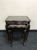 A nest of three inlaid mahogany glass top tables