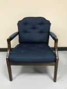 An oak framed armchair in blue button fabric