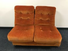 A mid 20th century two seater settee upholstered in orange button fabric