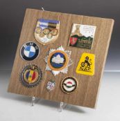 Konvolut von 7 versch. Auto-Plaketten, auf Holzplatte montiert, bestehend aus: a) 1. Internat.