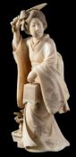 A Japanese carved ivory okimono: in the form of a bijin wearing a flowing kimono,