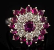 A ruby and diamond circular cluster ring: with single circular ruby within a surround of