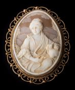 A 9ct gold oval shell cameo brooch: depicting a woman with a lapdog, within a pierced surround,