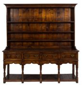 An 18th Century oak dresser with a later shelved superstructure:, having a moulded cornice,