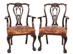 A pair of carved mahogany elbow chairs in the Chippendale taste:,
