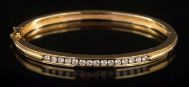 A diamond mounted hinged bangle: channel-set with a line of circular brilliant-cut diamonds