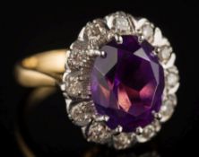 An amethyst and illusion-set diamond oval cluster ring: the oval amethyst approximately 12.