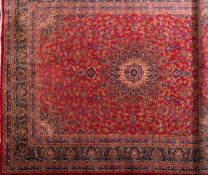 A Kashan carpet:, the red field with a central arabesque flowerhead pole medallion,