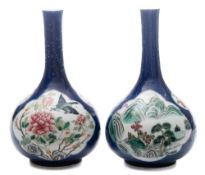 A pair of Chinese famille rose bottle vases: painted with panels of peacocks,