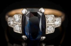 An 18ct gold, sapphire and diamond seven-stone ring: the rectangular sapphire approximately 10.