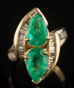An emerald and diamond mounted cluster crossover ring: with two pear-shaped emeralds,