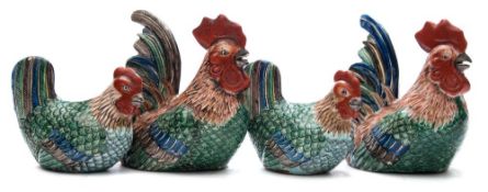 A group of four Chinese porcelain cockerel and hen groups: each in sitting posture under red, green,