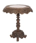 A 19th Century Indian carved wood circular occasional table:, the top with a wide band of foliage,