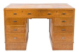 Harvey Nichols & Co, Ltd - A 1930's oak kneehole desk,: the top inset with a panel of leather,