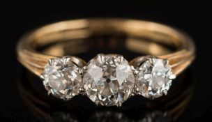 A graduated diamond three-stone ring: with circular old, brilliant-cut diamonds approximately 0.