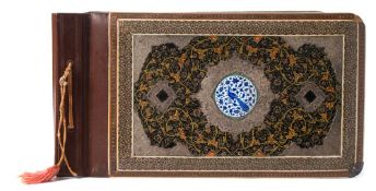 A Persian photograph album: the front board with central circular enamel panel of an exotic bird,