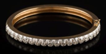 A diamond mounted hinged bangle: with twenty round European-cut diamonds each approximately 0.