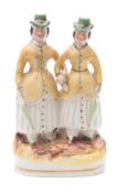 A Staffordshire pottery group of the 'Alphington Ponies': the Durnford sisters arm-in-arm,