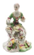 An early Derby 'pale family' figure of a seated lady: wearing a puce and gilt trimmed green bodice,