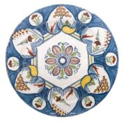 A mid 18th century Dutch polychrome delftware charger: painted with stylised flowers,