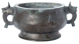 A Chinese inlaid bronze censer: the compressed circular body with animal mask handles and inlaid