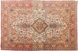 A Qum rug:, the ivory cartouche field with a central light brown flowerhead pole medallion,