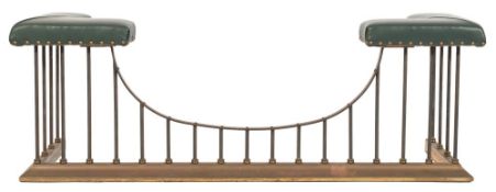 A contemporary brass and oxidised metal club fender:, the corner seats upholstered in green leather,