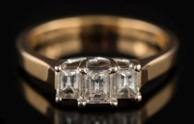 An 18ct gold step-cut diamond three-stone ring:, total diamond weight approximately 0.