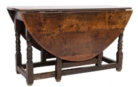 An 18th Century oak oval gateleg dining table:, with a hinged top,