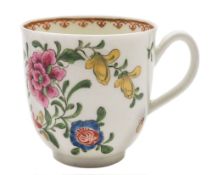 A First Period Worcester coffee cup: painted in bright famille rose colours with a large peony and