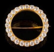 A gold and diamond surround circular brooch: with twenty four round old brilliant-cut diamonds