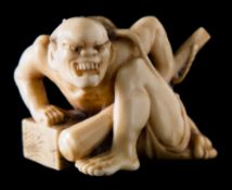 A Japanese carved ivory okimono of a rat catcher: crouching and holding a kanabo,
