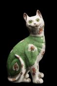 A Galle-style pottery cat: modelled seated and transfer decorated with flowers on a green waistcoat,