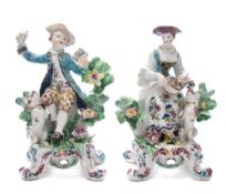 A pair of Bow figures of musicians: in the form of a lady playing a hurdy-gurdy, a dog at her feet,