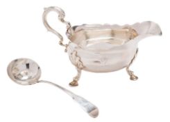 A Georgian silver sauce boat, all marks worn: of traditional design with wavy-edge border,
