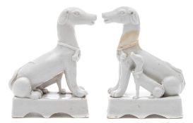 Two Chinese blanc de Chine dogs: each modelled seated with a puppy at its side,