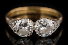 An 18ct gold and diamond two-stone ring: with circular,