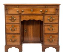 A George III mahogany kneehole desk:, the rectangular top with a moulded edge, fitted with a slide,