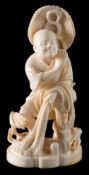 A Japanese carved ivory okimono: of a fisherman standing with his net, in traditional costume,