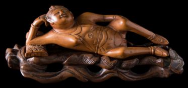 A Chinese carved boxwood doctor's female medicine doll: reclining on a pillow,